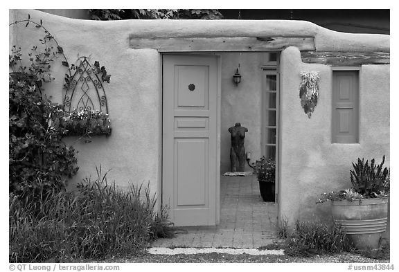 Adobe style walls, blue doors and windows, and courtyard. Taos, New Mexico, USA (black and white)