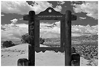 Historic marker framing high desert landscape. New Mexico, USA (black and white)