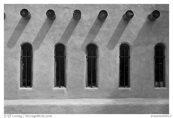 Facade with vigas (heavy timbers) extending through walls to support roof, Chimayo sanctuary. New Mexico, USA (black and white)