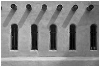 Facade with vigas (heavy timbers) extending through walls to support roof, Chimayo sanctuary. New Mexico, USA (black and white)