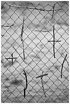 Crosses made of twigs on chain-link fence, Sanctuario de Chimayo. New Mexico, USA (black and white)