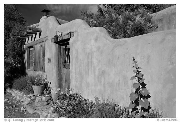 Adobe wall and weathered wooden door and window. Santa Fe, New Mexico, USA (black and white)