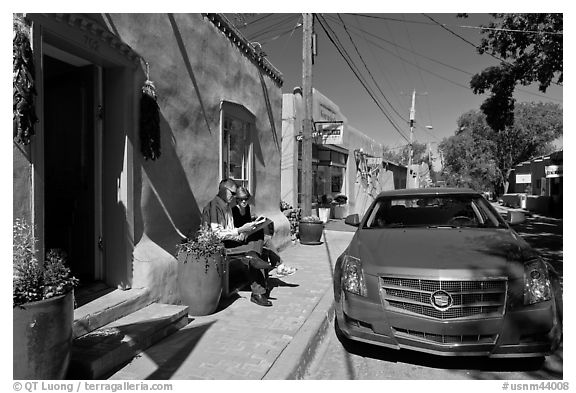Couple reading art magazine in front of gallery. Santa Fe, New Mexico, USA (black and white)