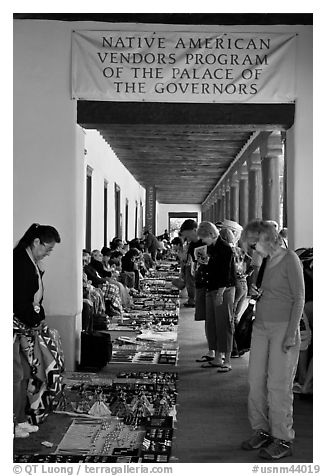 Tourists browse wares sold under native american vendors program of the palace of the governors. Santa Fe, New Mexico, USA (black and white)