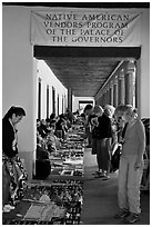 Tourists browse wares sold under native american vendors program of the palace of the governors. Santa Fe, New Mexico, USA (black and white)