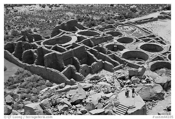 Tourists inspecting the complex room arrangement of Pueblo Bonito. Chaco Culture National Historic Park, New Mexico, USA (black and white)