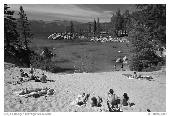Young people sunbathing on sandy beach, Sand Harbor, Lake Tahoe, Nevada. USA (black and white)