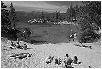 Young people sunbathing on sandy beach, Sand Harbor, Lake Tahoe, Nevada. USA (black and white)