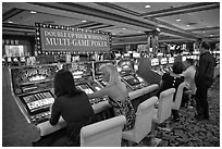 Gambling with gaming  machines. Las Vegas, Nevada, USA (black and white)