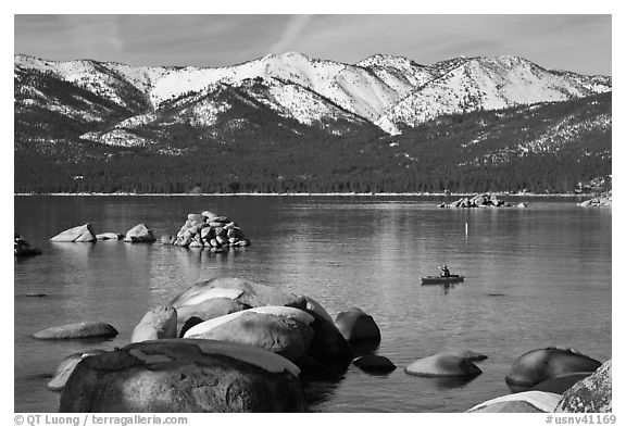 Boulders, kayak, and snowy mountains, Sand Harbor, Lake Tahoe-Nevada State Park, Nevada. USA (black and white)