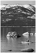 Kayaker with backdrop of snow-covered mountains, Lake Tahoe-Nevada State Park, Nevada. USA (black and white)