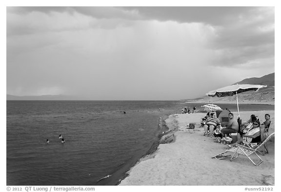 People lounging with beach chairs and umbrellas. Pyramid Lake, Nevada, USA (black and white)