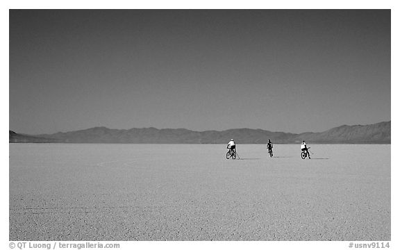 Three bicyclists on the desert Playa, Black Rock Desert. Nevada, USA (black and white)