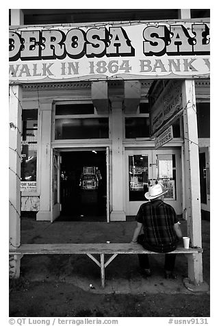 Man with cowboy hat sitting in front of a casino. Virginia City, Nevada, USA (black and white)