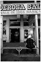 Man with cowboy hat sitting in front of a casino. Virginia City, Nevada, USA (black and white)