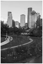 People walking in park with skyline behind. Houston, Texas, USA ( black and white)