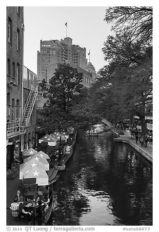 Riverwalk promenade, approaching barge. San Antonio, Texas, USA (black and white)