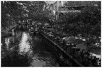 Restaurant tables and barge, Riverwalk. San Antonio, Texas, USA ( black and white)