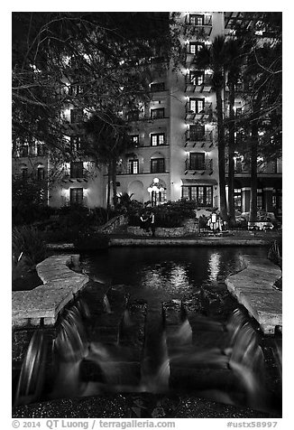 Waterfall, elegant couple in distance. San Antonio, Texas, USA (black and white)