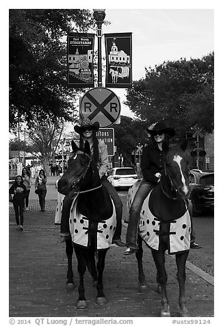 Women riding horses on sidewalk, Stockyards. Fort Worth, Texas, USA (black and white)