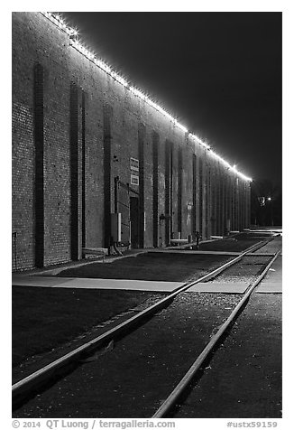 Railroad tracks and brick buildings at night, Stockyards. Fort Worth, Texas, USA (black and white)