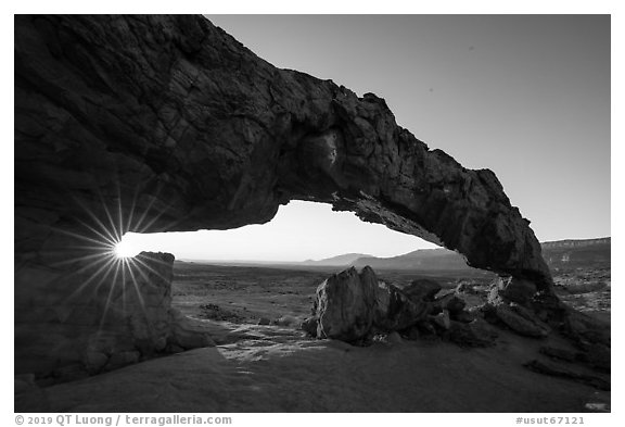 Sunstar through Sunset Arch. Grand Staircase Escalante National Monument, Utah, USA (black and white)