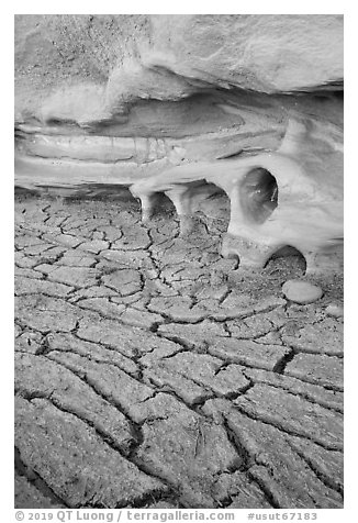 Cracked mud and cliff with holes. Grand Staircase Escalante National Monument, Utah, USA (black and white)