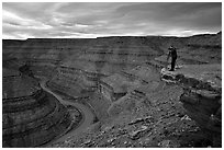 Photographer on overhang above the San Juan River, Goosenecks of the San Juan State Park. Utah, USA (black and white)