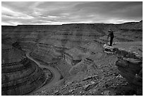 Photographer on overhang above the San Juan River, Goosenecks of the San Juan State Park. Utah, USA (black and white)