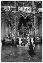 Woman praying at the altar. Ho Chi Minh City, Vietnam ( black and white)