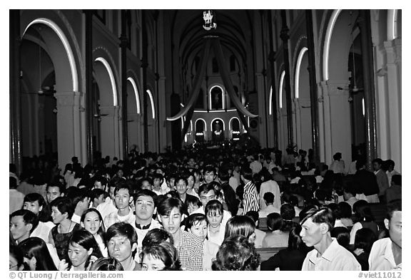 Crowds exit the Cathedral St Joseph at the end of the Christmas mass. Ho Chi Minh City, Vietnam (black and white)