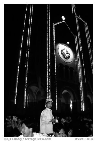 Child with christmas hat in front of St Joseph Cathedral on Christmas eve. Ho Chi Minh City, Vietnam (black and white)