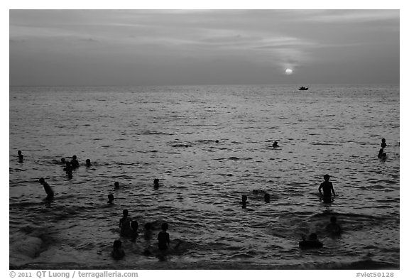 People bathing in Gulf of Thailand waters at sunset. Phu Quoc Island, Vietnam