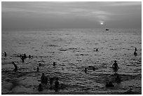 People bathing in Gulf of Thailand waters at sunset. Phu Quoc Island, Vietnam ( black and white)