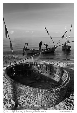 Fishermen pulling net out of circular basket. Phu Quoc Island, Vietnam (black and white)