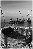 Fishermen pulling net out of circular basket. Phu Quoc Island, Vietnam ( black and white)