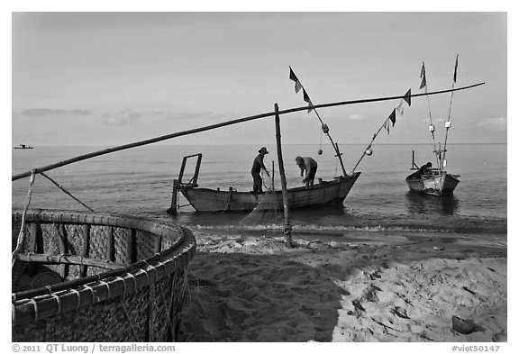 Fishermen pulling net onto skiff. Phu Quoc Island, Vietnam (black and white)