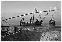 Fishermen pulling net onto skiff. Phu Quoc Island, Vietnam (black and white)