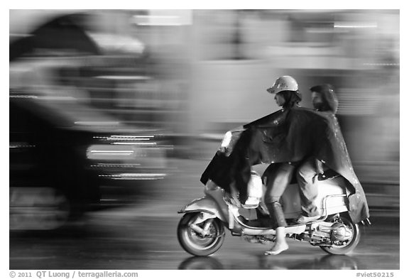 Women riding scooter in the rain. Ho Chi Minh City, Vietnam