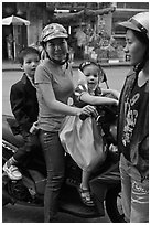 Woman riding with children. Ho Chi Minh City, Vietnam (black and white)