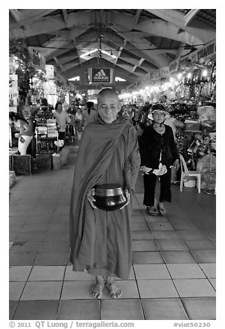 Buddhist Monk doing alms round in Ben Thanh Market. Ho Chi Minh City, Vietnam (black and white)