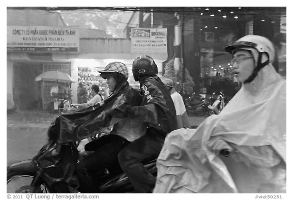 Motorcycle riders during afternoon mooson. Ho Chi Minh City, Vietnam (black and white)