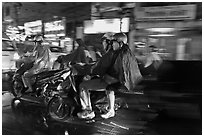 Motorcyle riders at night, dressed for the rain. Ho Chi Minh City, Vietnam ( black and white)