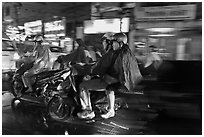 Motorcyle riders at night, dressed for the rain. Ho Chi Minh City, Vietnam (black and white)