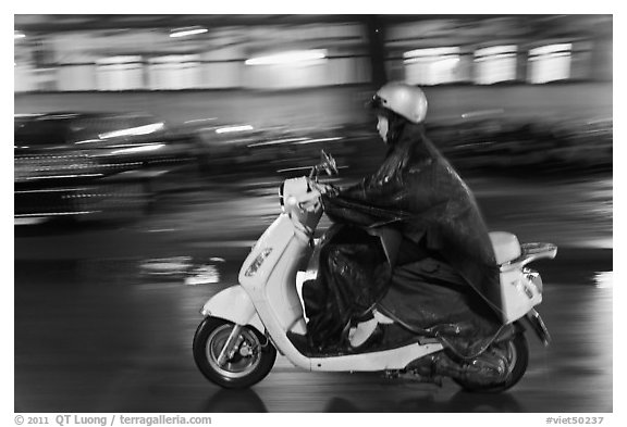 Scooter rider on rainy night. Ho Chi Minh City, Vietnam (black and white)