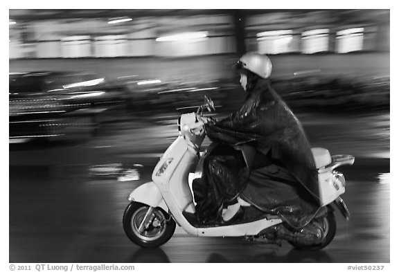 Scooter rider on rainy night. Ho Chi Minh City, Vietnam