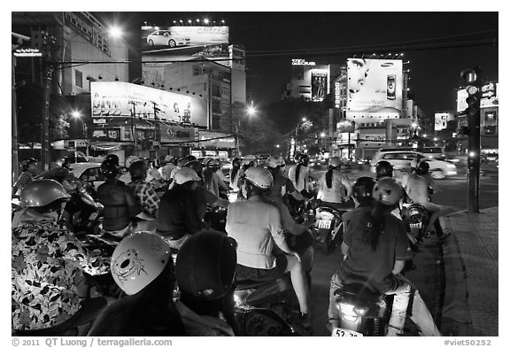 Motorbikes waiting at traffic light at night. Ho Chi Minh City, Vietnam