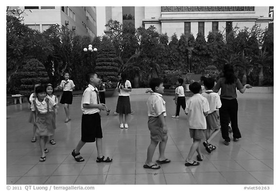 Children walking in circle in park. Ho Chi Minh City, Vietnam (black and white)