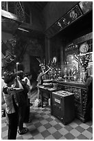 Women at altar, Phuoc Hai Tu temple, district 3. Ho Chi Minh City, Vietnam (black and white)