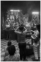 Women offering incense to Jade Emperor figure, Phuoc Hai Tu pagoda, district 3. Ho Chi Minh City, Vietnam (black and white)